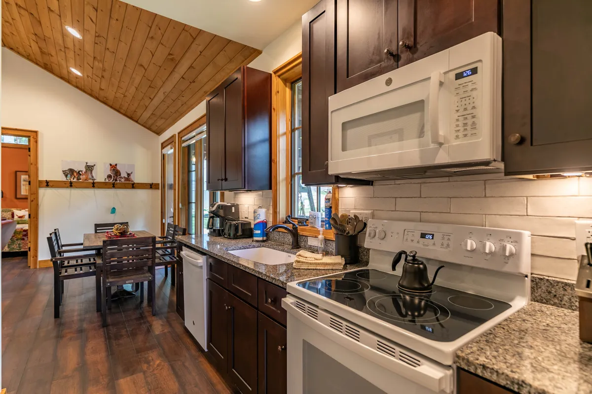 A cozy, well-equipped kitchen with a central island, stainless steel appliances, and a welcoming dining table. The space is designed for gatherings, whether preparing a group meal or enjoying coffee before a day of exploration.