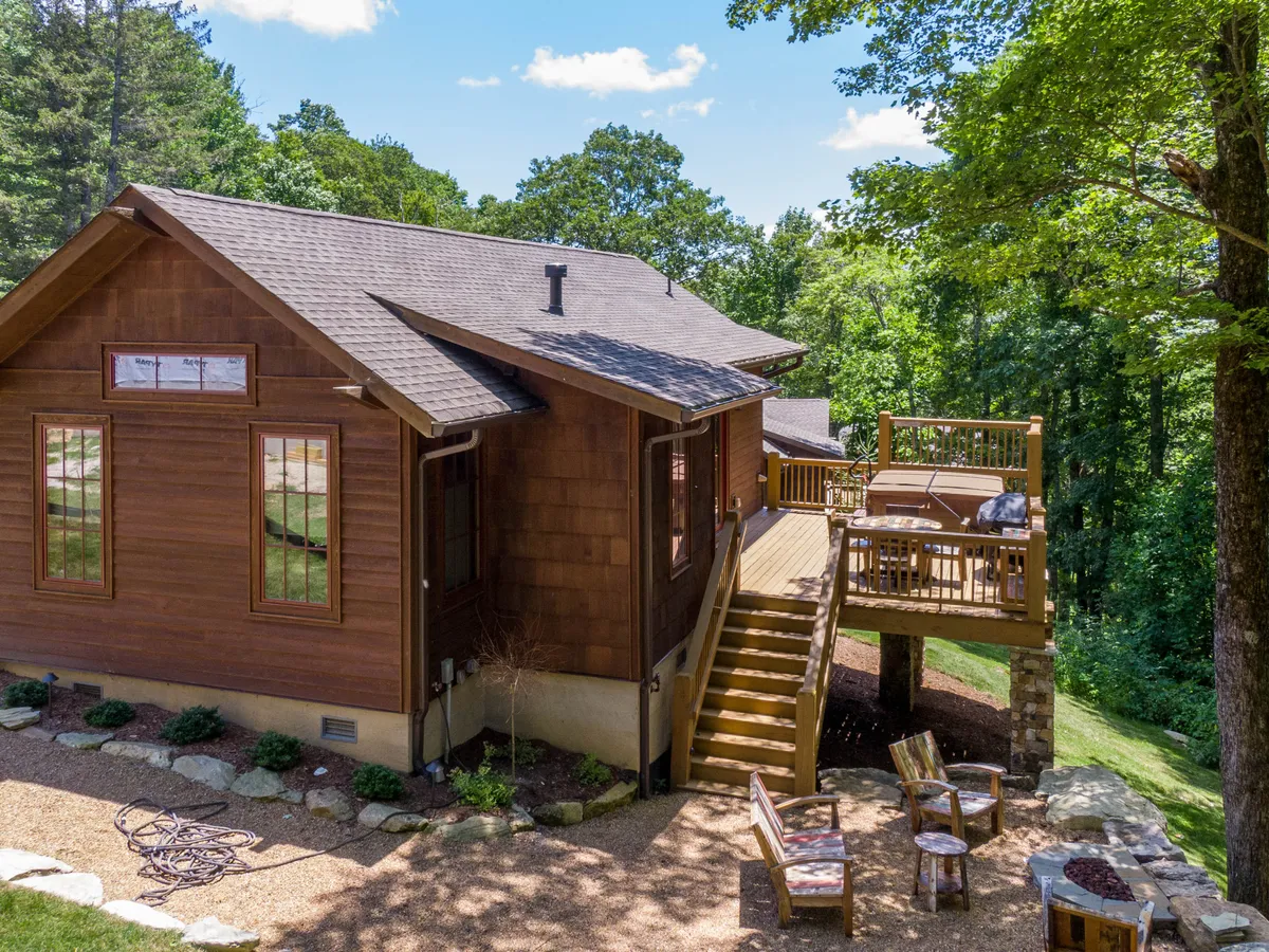 A spacious wooden deck with comfortable seating, set against a backdrop of rich, green foliage. The deck offers a peaceful space for enjoying morning coffee, reading, or simply reveling in the natural setting.
